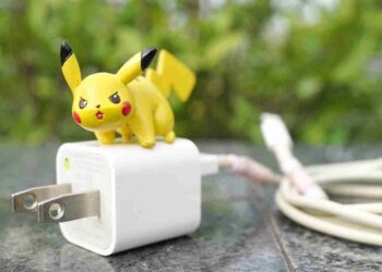 Giocattolo di Pikachu, famoso Pokémon elettro, appoggiato su un caricabatterie.