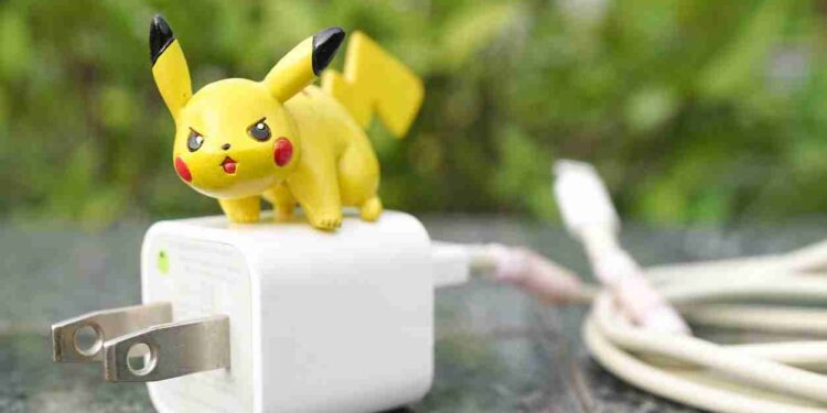 Giocattolo di Pikachu, famoso Pokémon elettro, appoggiato su un caricabatterie.