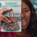 Una ragazza tiene in mano un libro di Debbie Macomber